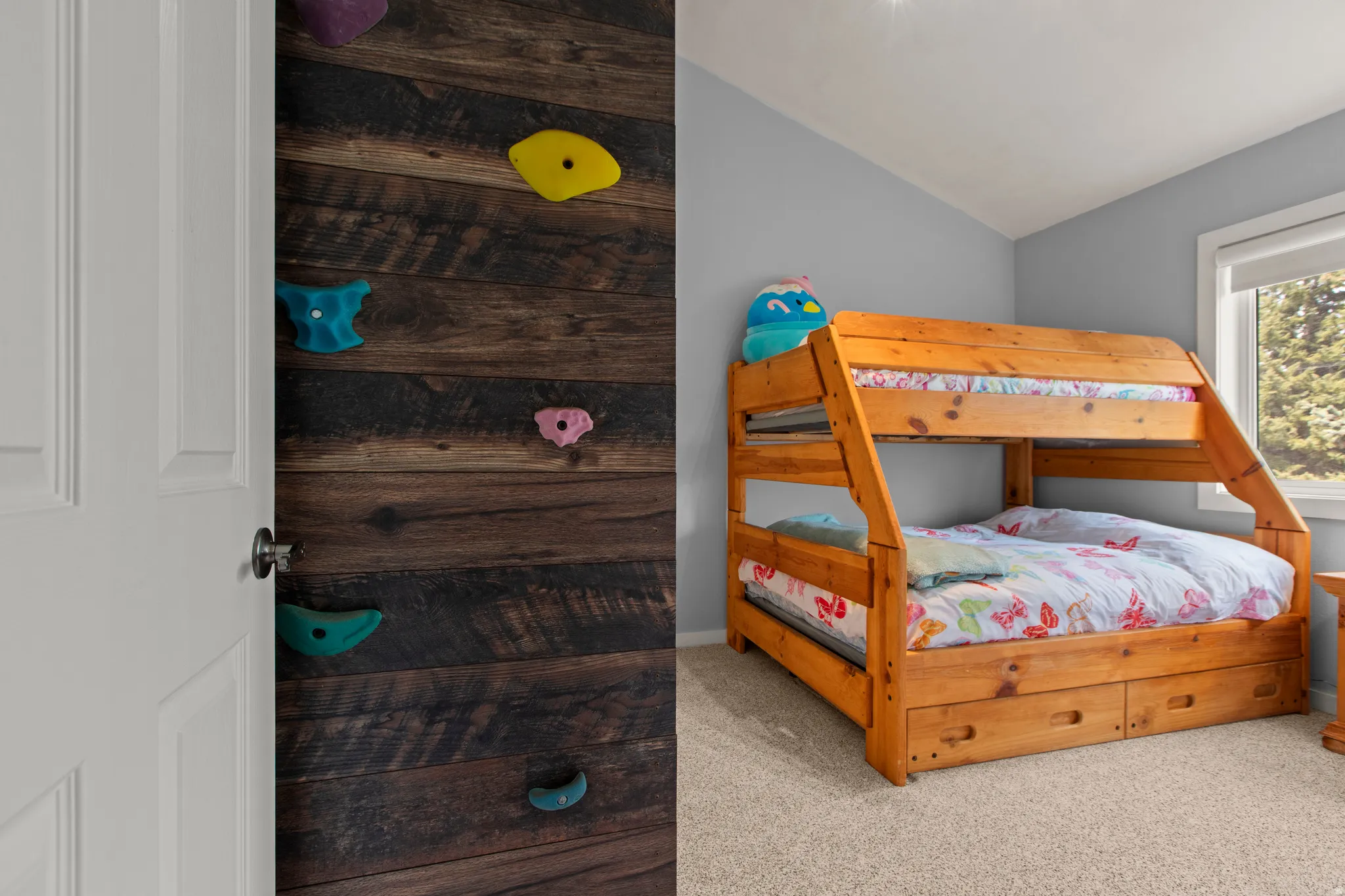 Bedroom with light carpet and lofted ceiling