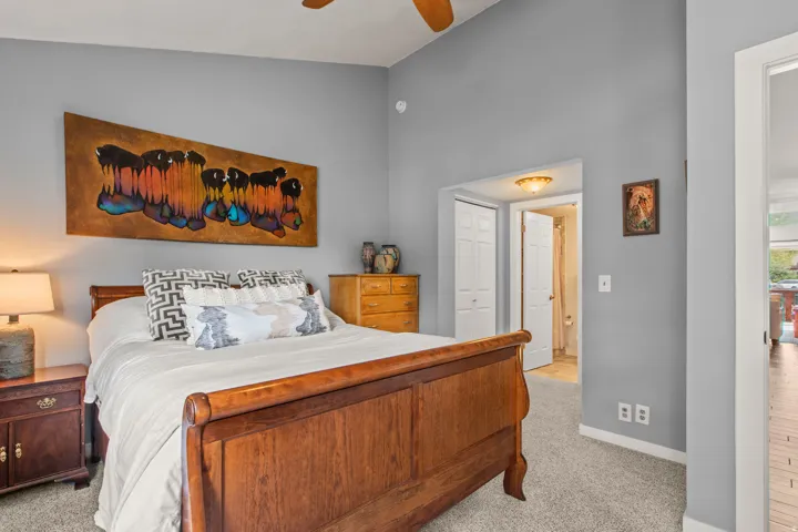 Bedroom featuring light carpet, a closet, ceiling fan, and vaulted ceiling
