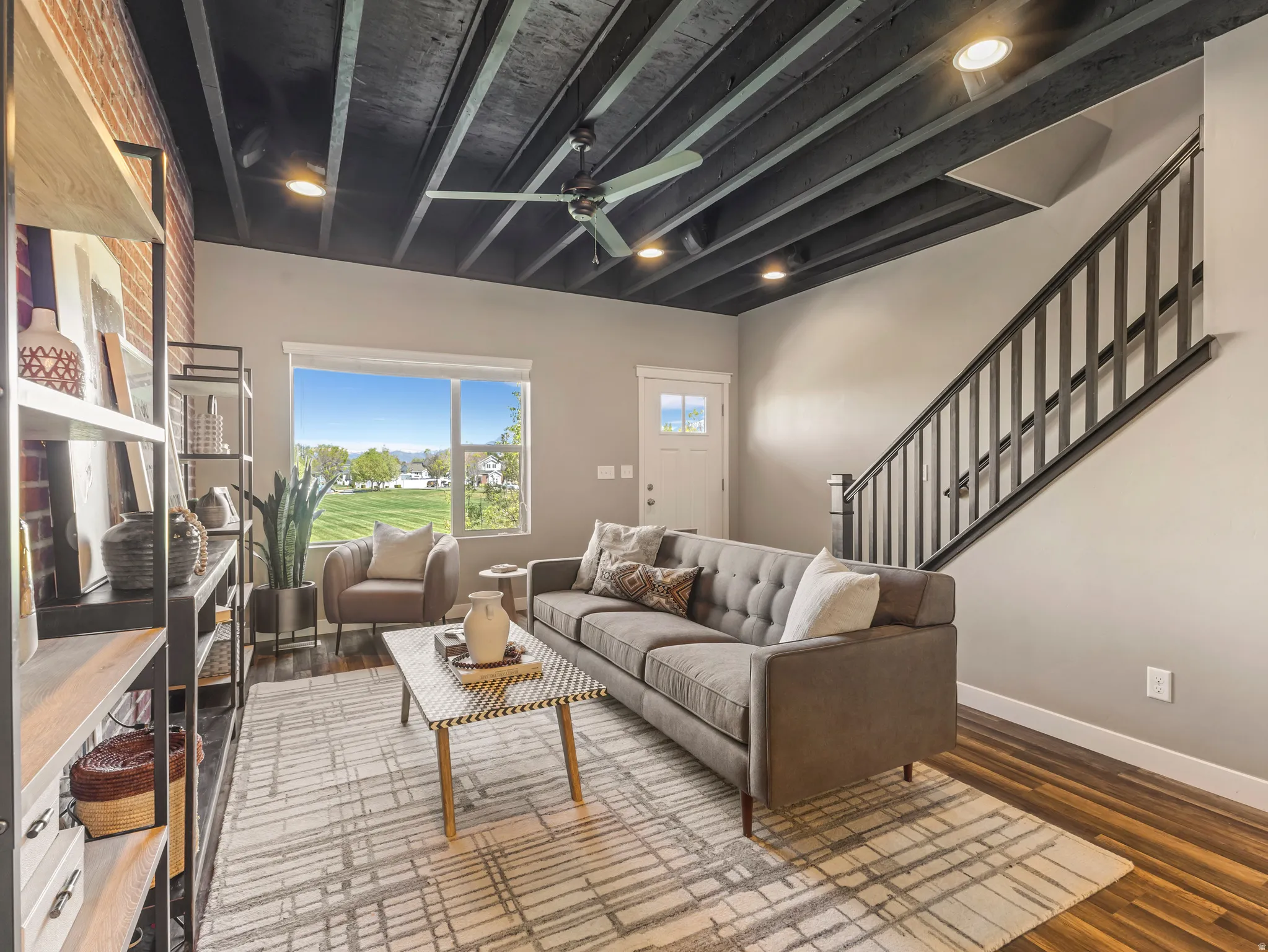 Living area featuring beam ceiling, a ceiling fan, wood finished floors, and recessed lighting