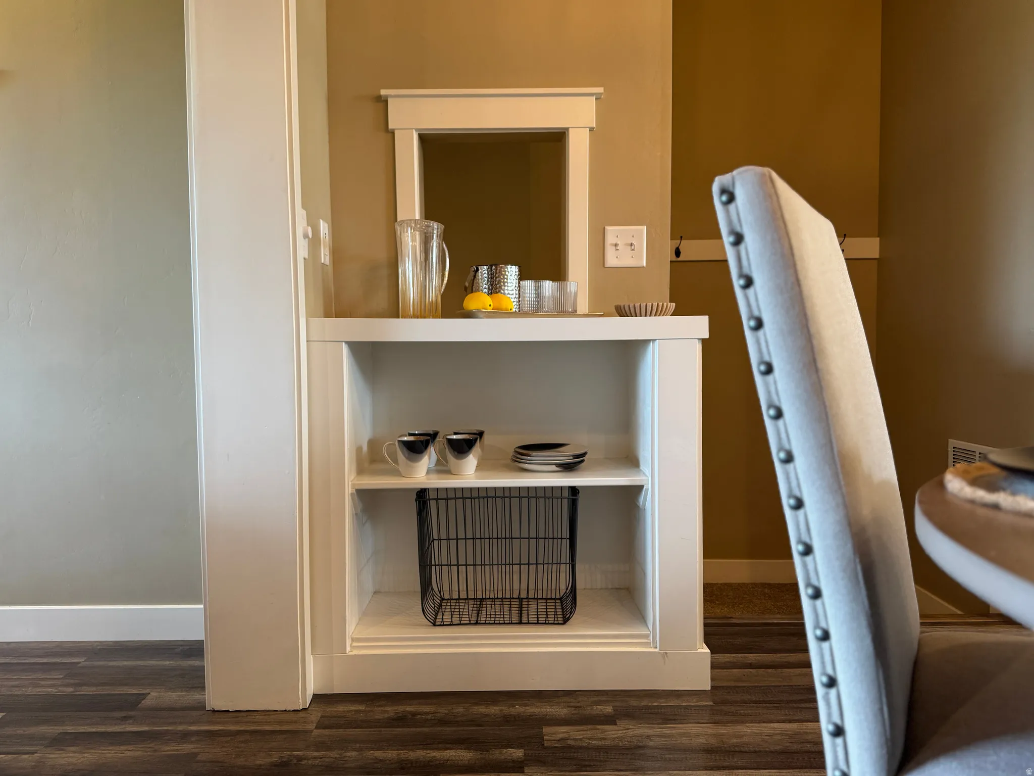 Detailed view of dark wood-style flooring and baseboards and custom built-in shelving