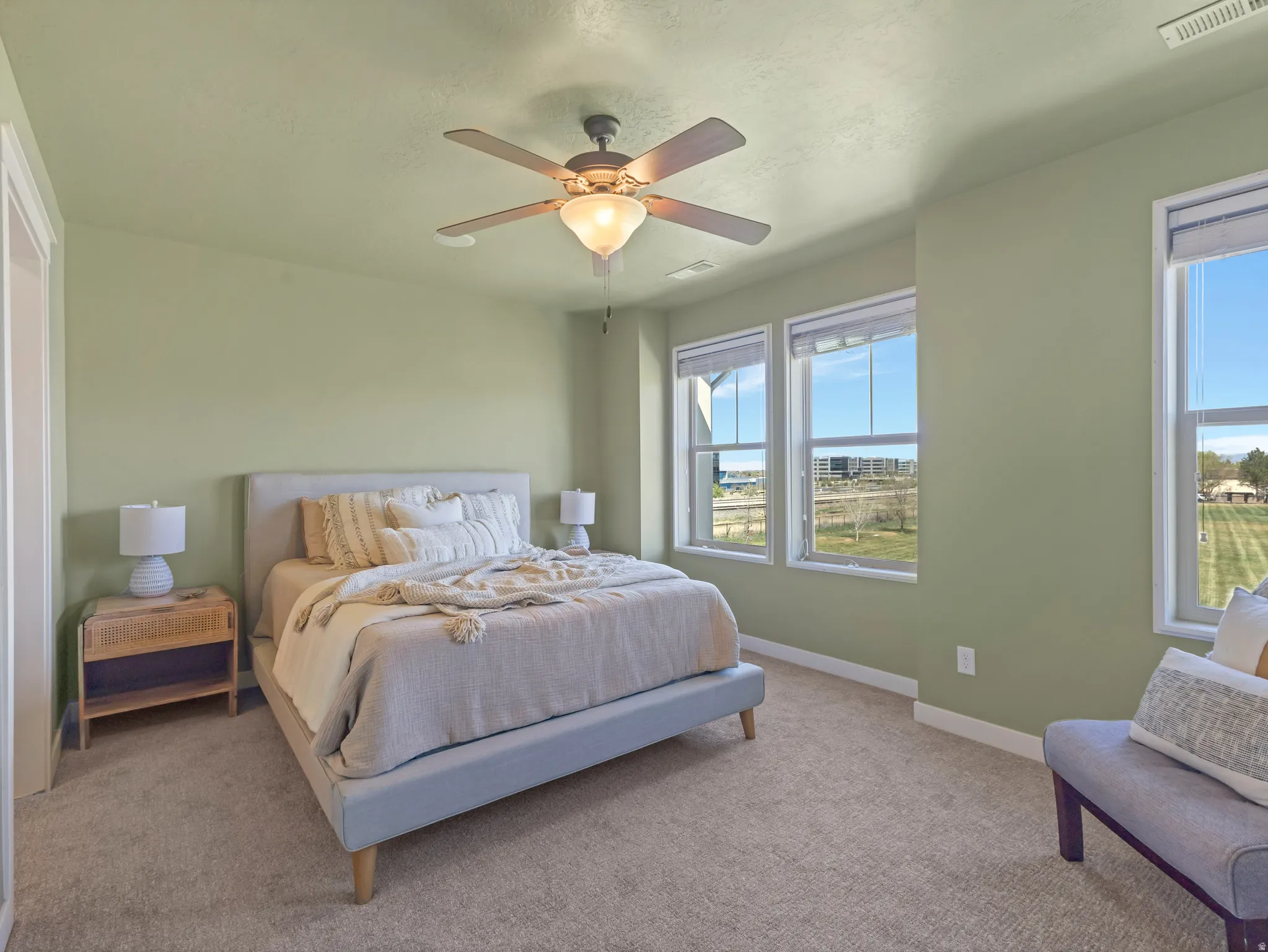 Primary Bedroom featuring light carpet and ceiling fan