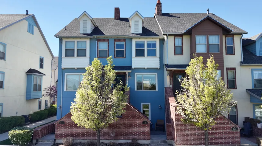 View of front of house featuring a chimney and a shingled roof