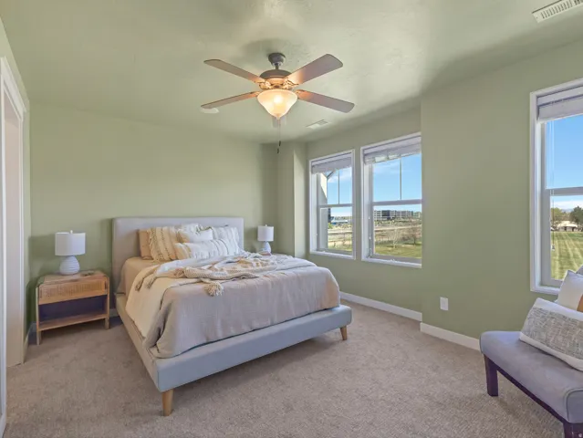 Primary Bedroom featuring light carpet and ceiling fan