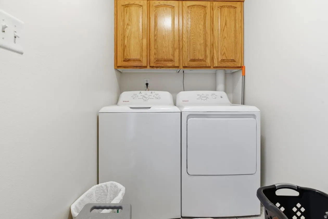 Laundry room with cabinet space and washer and clothes dryer