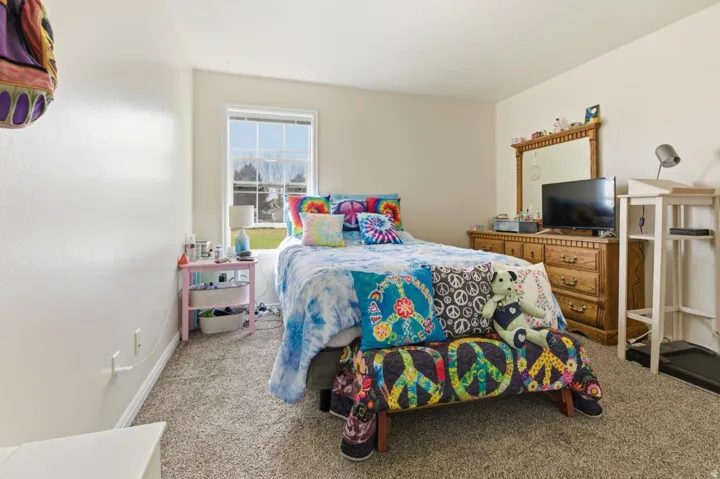 Bedroom with light colored carpet and baseboards