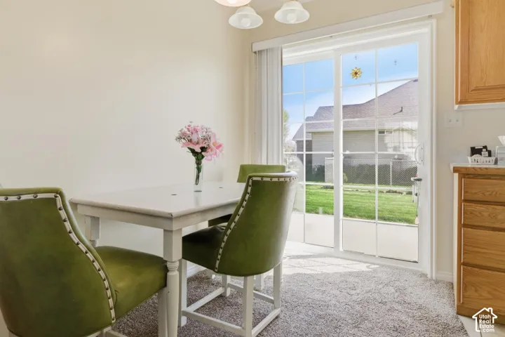 Dining room with light colored carpet and suspended lighting