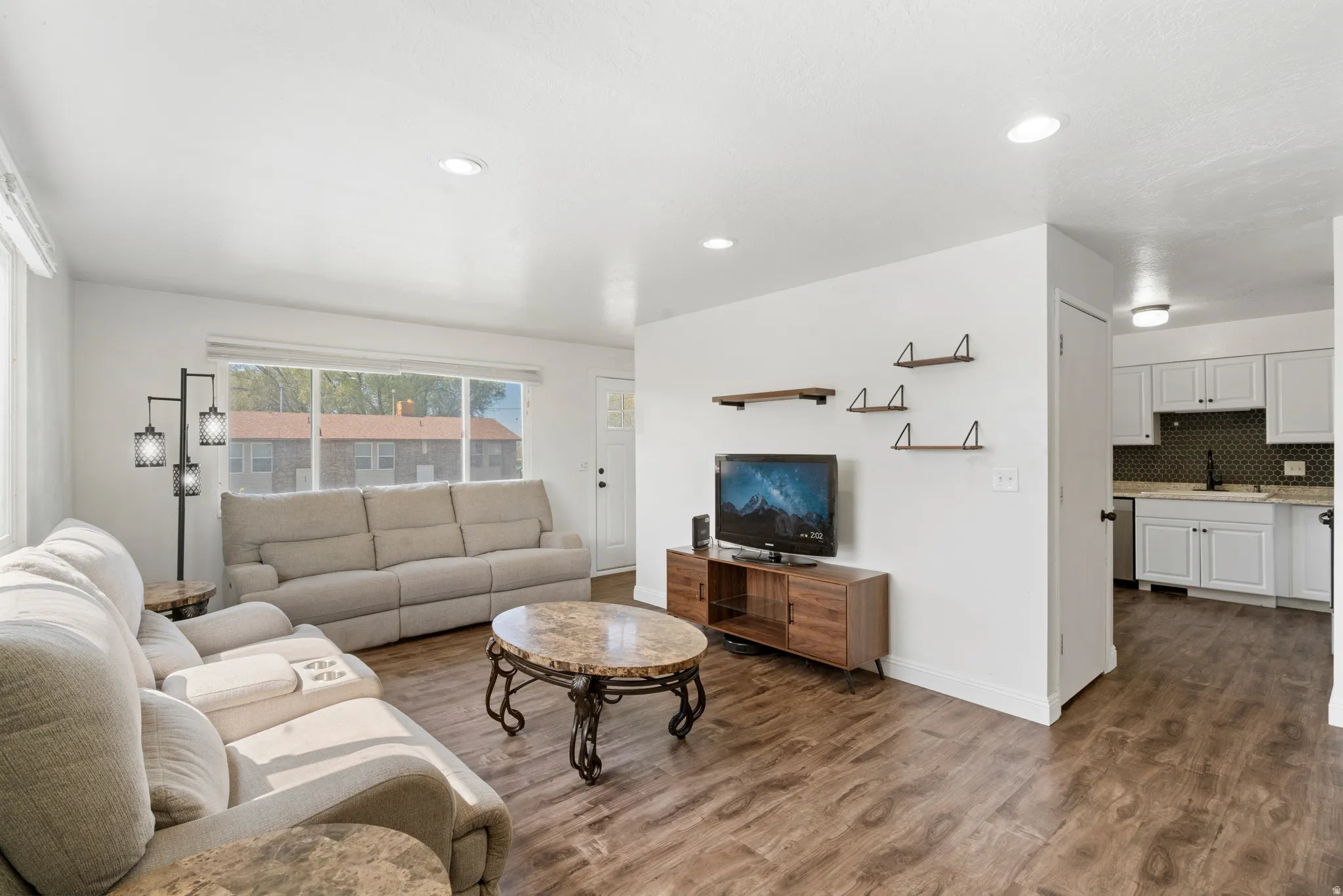 Living area with dark wood-type flooring and recessed lighting