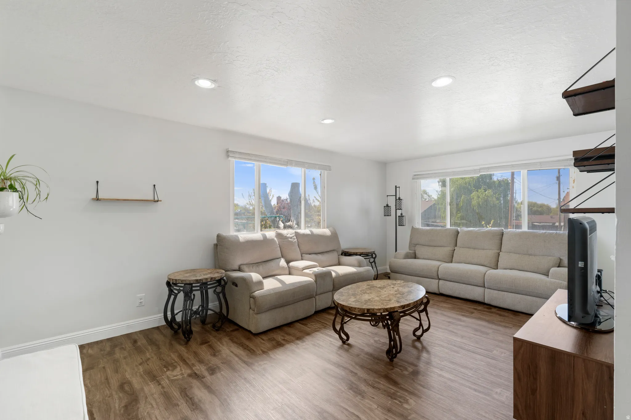 Living area with wood finished floors, recessed lighting, and a textured ceiling