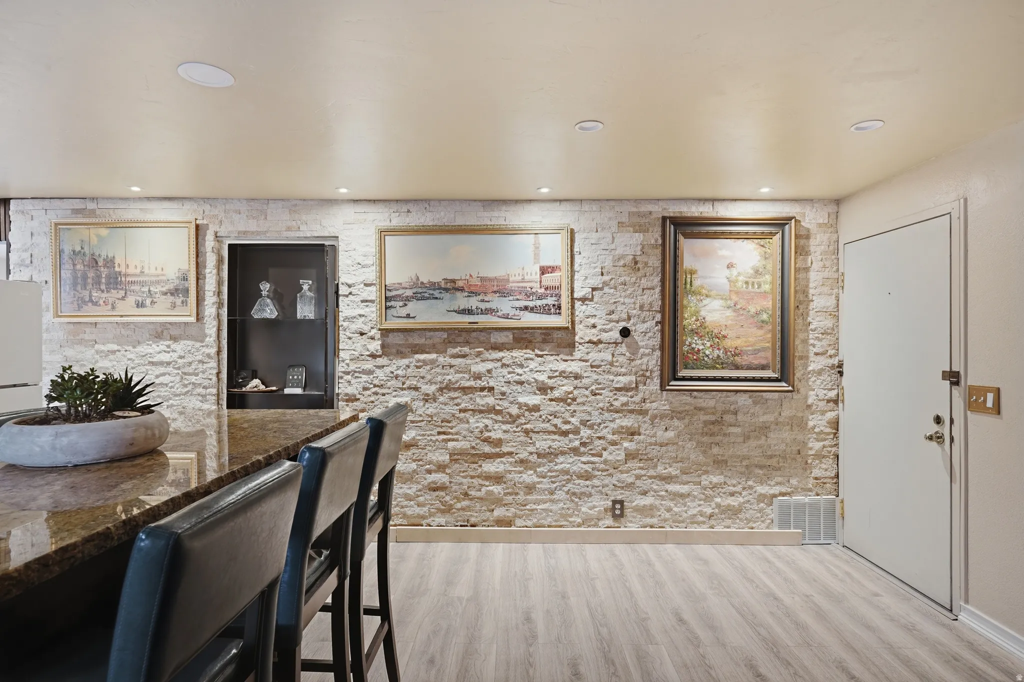 Dining space featuring light wood-style flooring, recessed lighting, and bar with sink