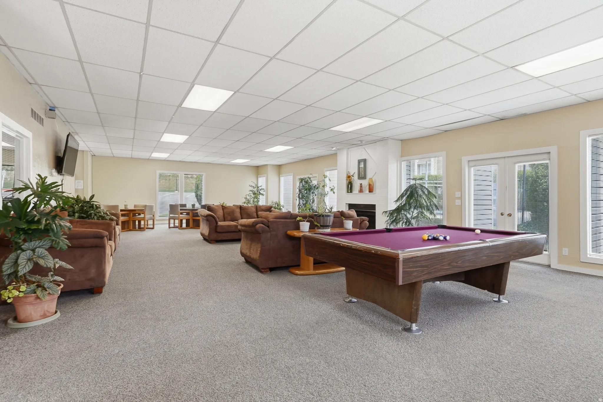 Rec room featuring french doors, billiards table, a paneled ceiling, and a fireplace