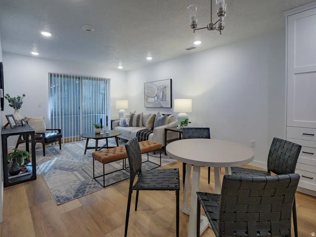 Dining space with light wood-style flooring, a textured ceiling, and recessed lighting