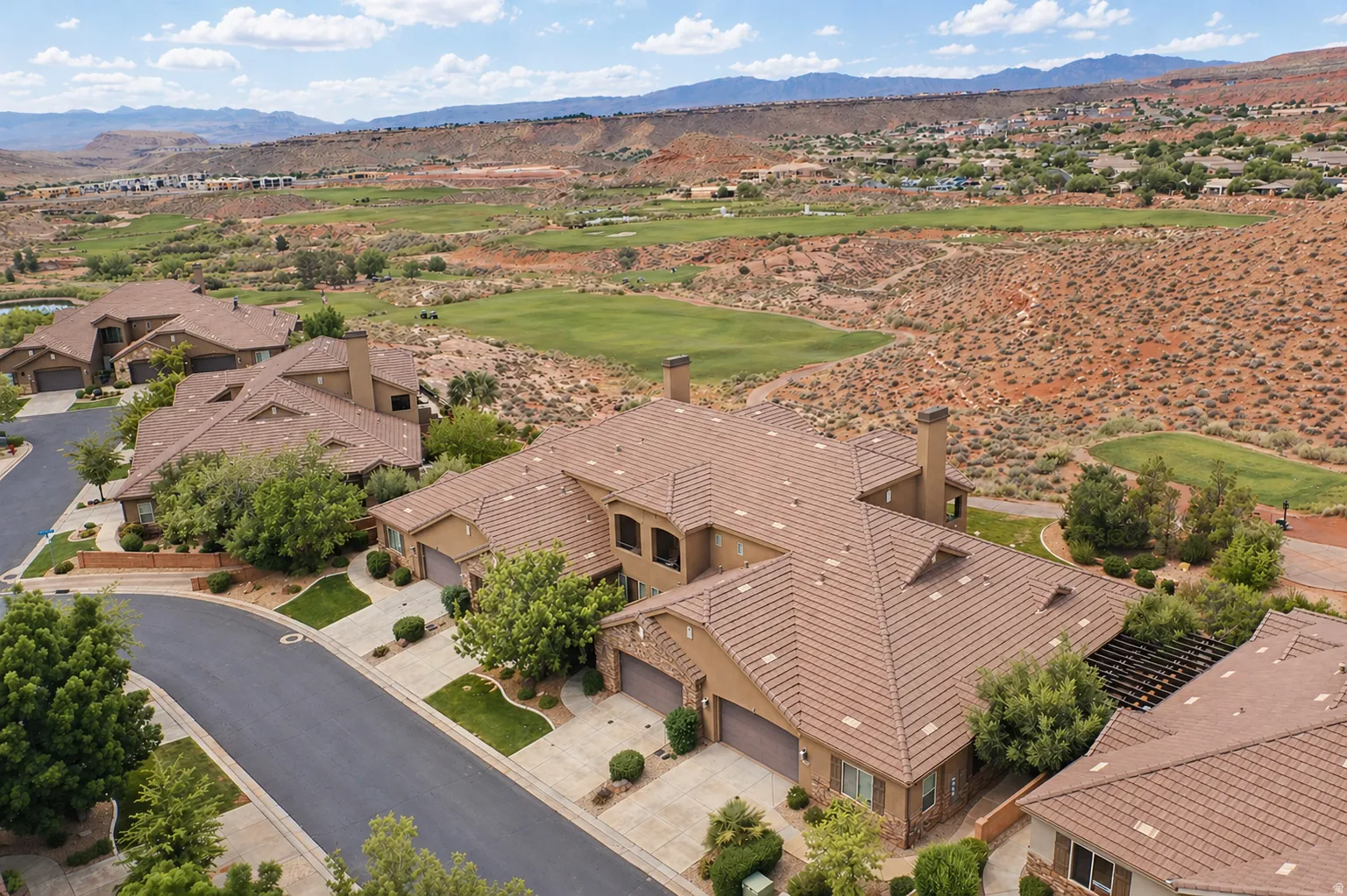 Aerial perspective of suburban area with mountains and a golf course