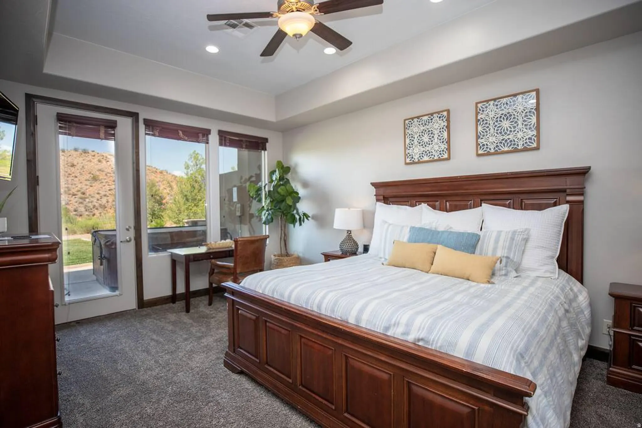 Bedroom with dark colored carpet, a raised ceiling, access to exterior, ceiling fan, and recessed lighting