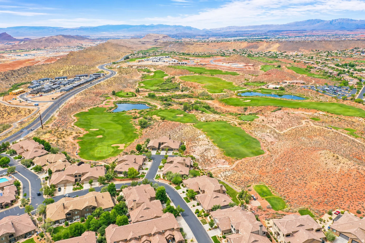Aerial perspective of suburban area with a water and mountain view and a golf club