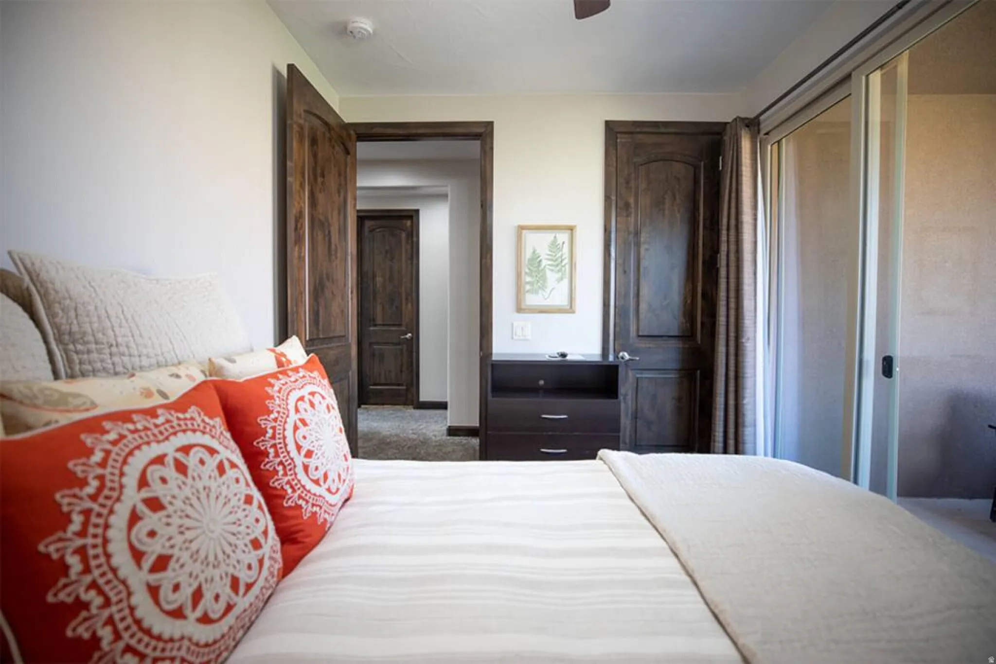 Bedroom with dark carpet, ceiling fan, and a closet