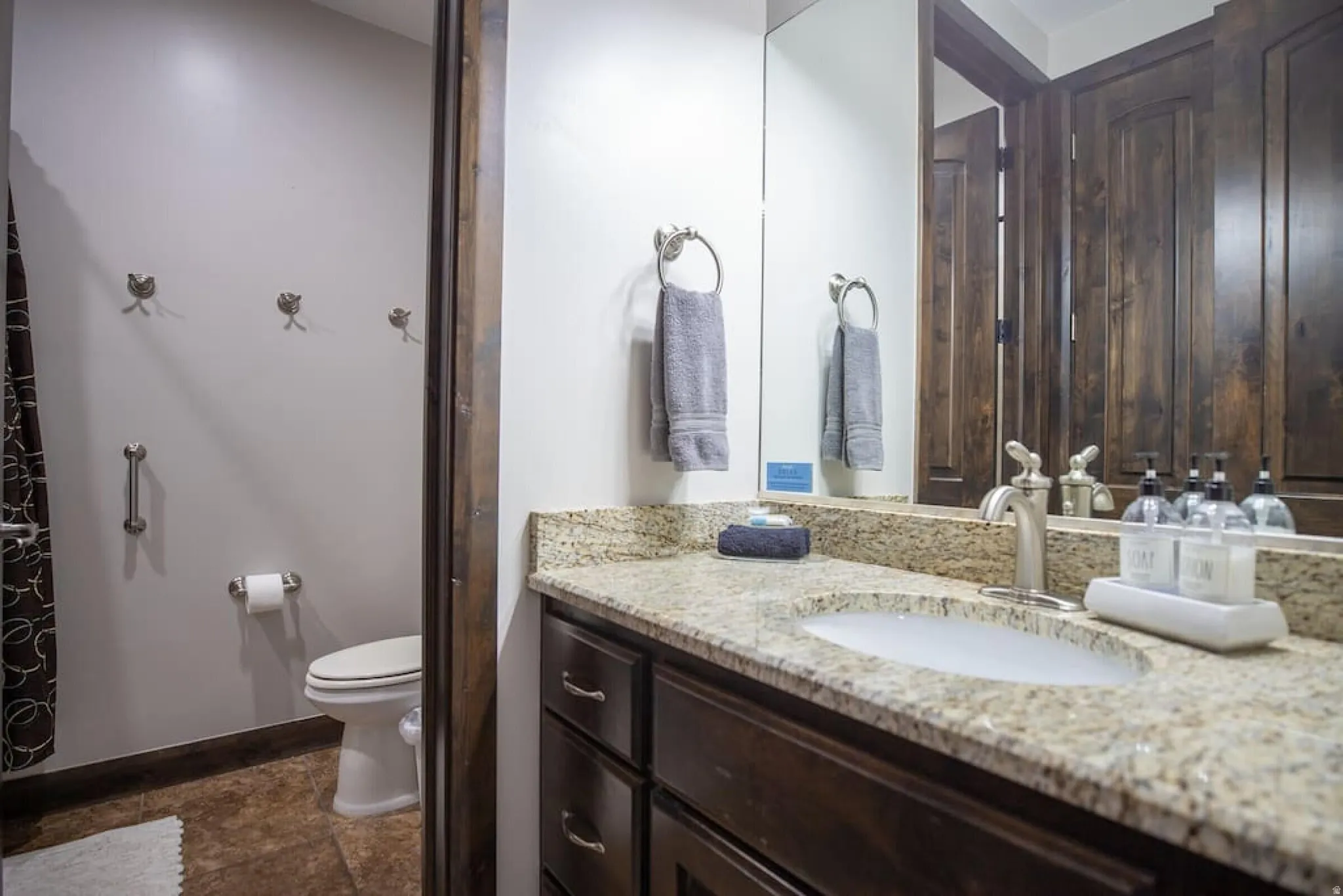 Bathroom with vanity and dark stone finish flooring