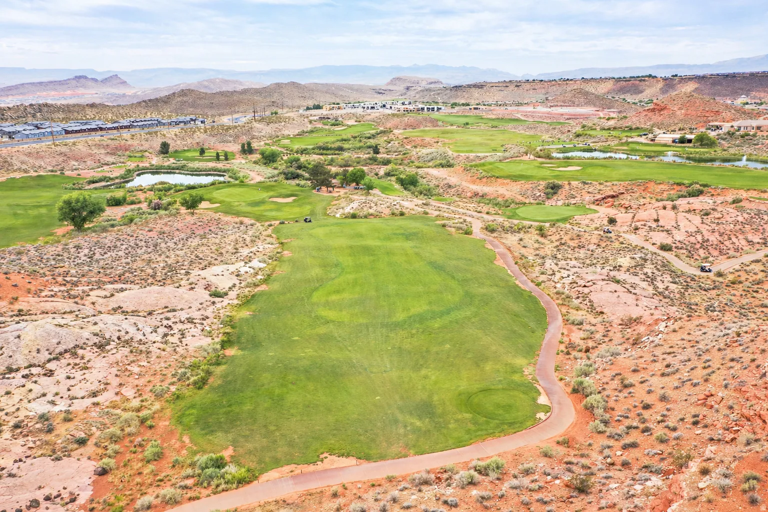Drone / aerial view of a water and mountain view and a golf course