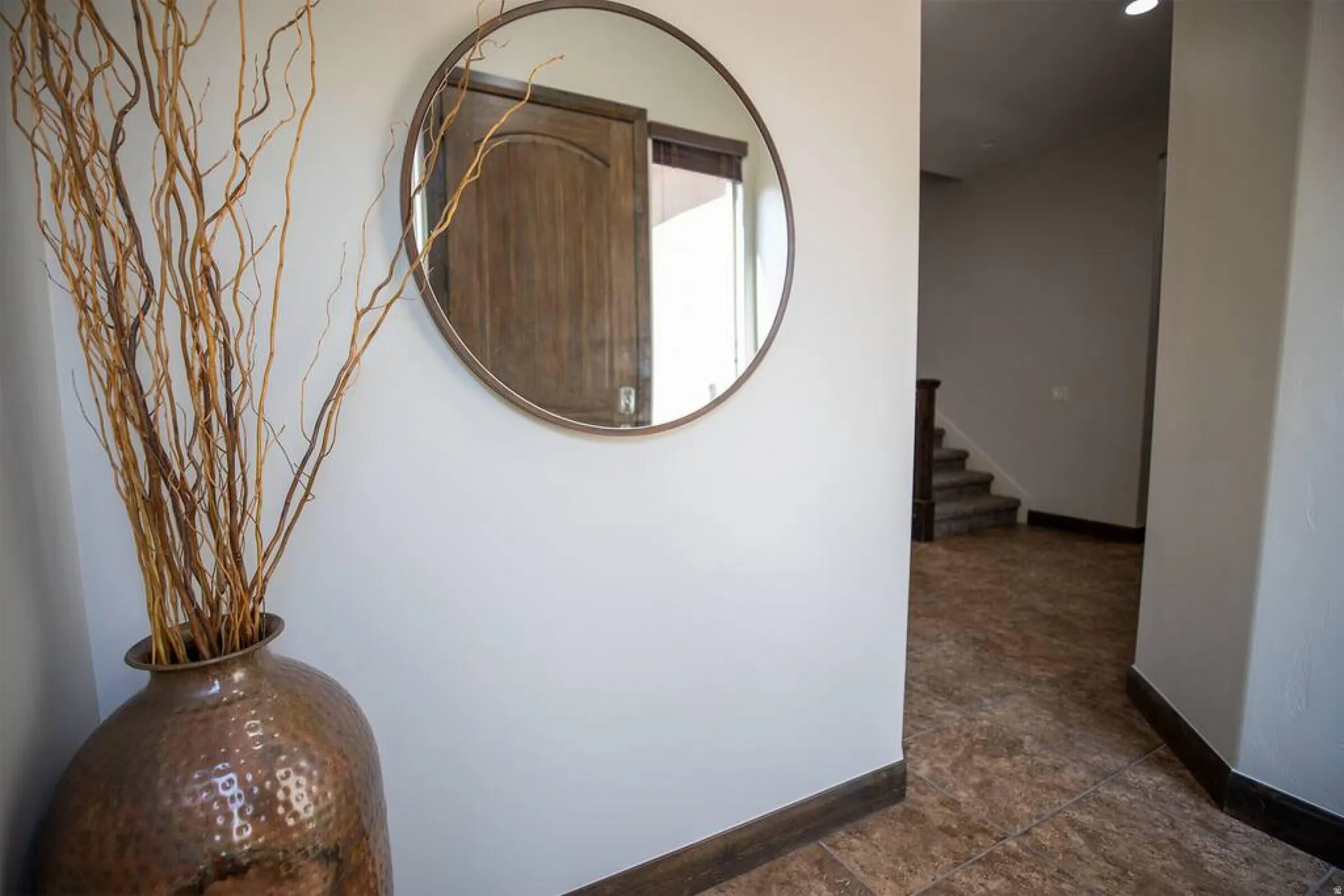 Hallway featuring stairway and baseboards