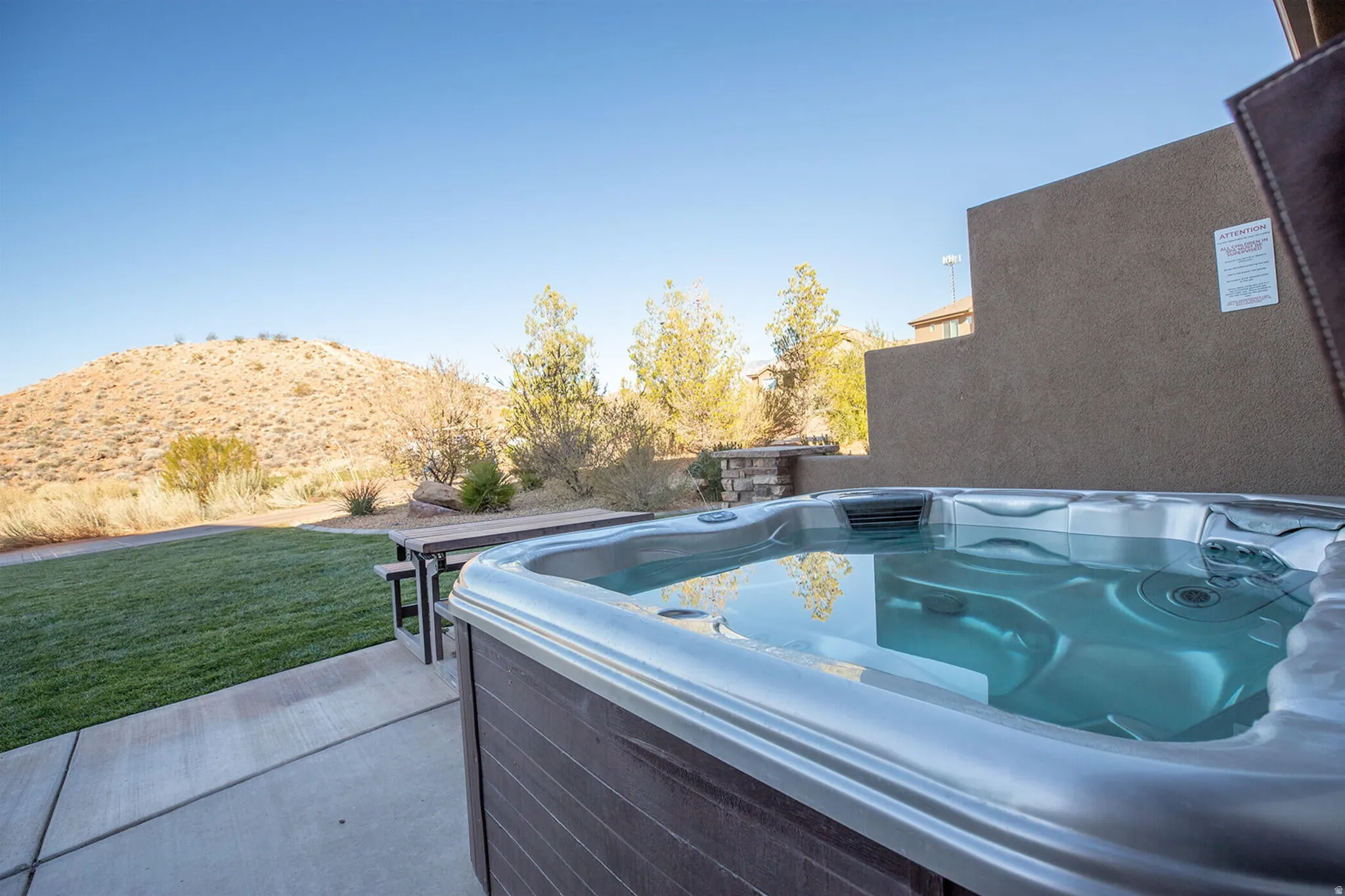 View of patio / terrace featuring a hot tub and a mountain view