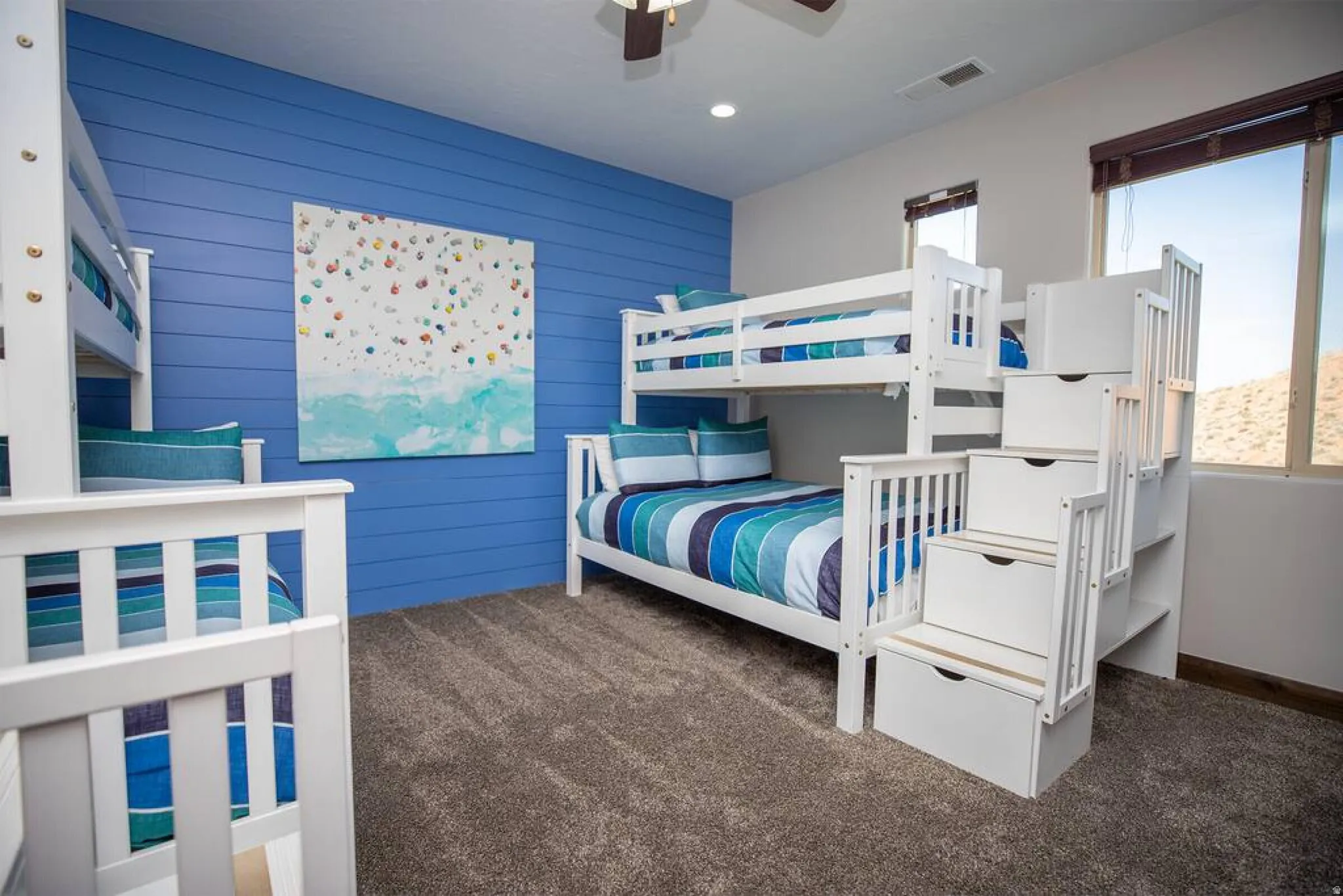 Carpeted bedroom with wood walls, ceiling fan, recessed lighting, and an accent wall
