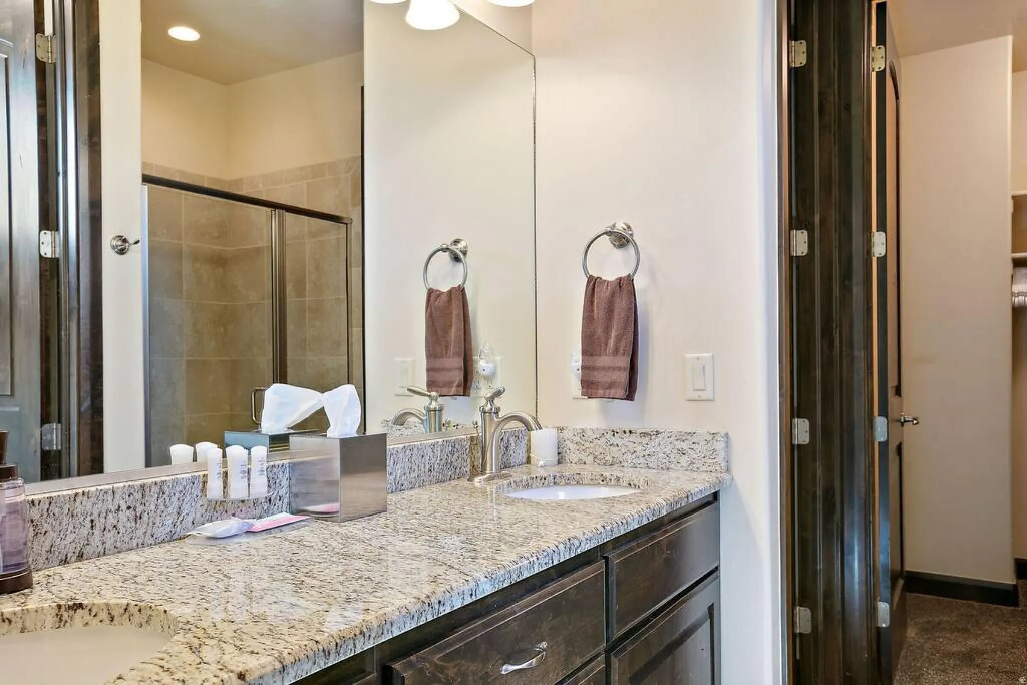 Full bath with double vanity and a stall shower
