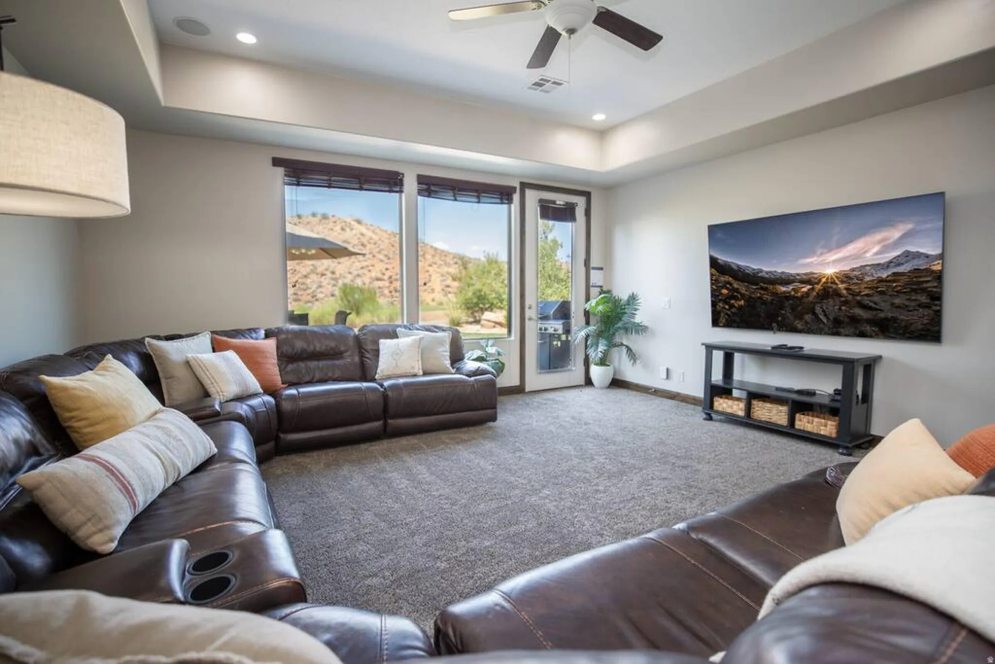 Living area featuring a tray ceiling, carpet floors, a ceiling fan, and recessed lighting
