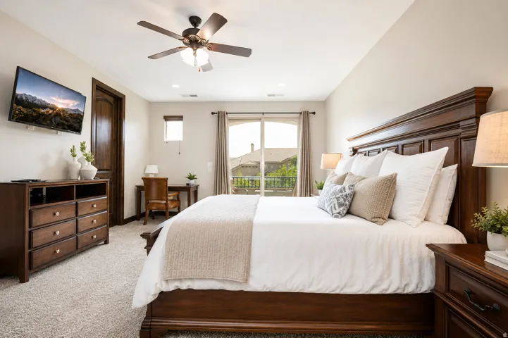 Spacious room featuring carpeting, a ceiling fan with integrated lighting, and a sliding glass door leading to a balcony