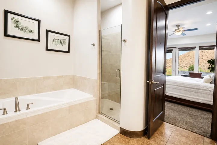 Built-in soaking tub with tile surround, adjacent to a glass-enclosed shower