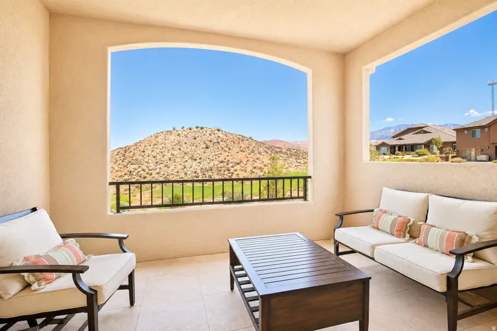Covered patio with textured stucco walls, arched openings, and black metal railings