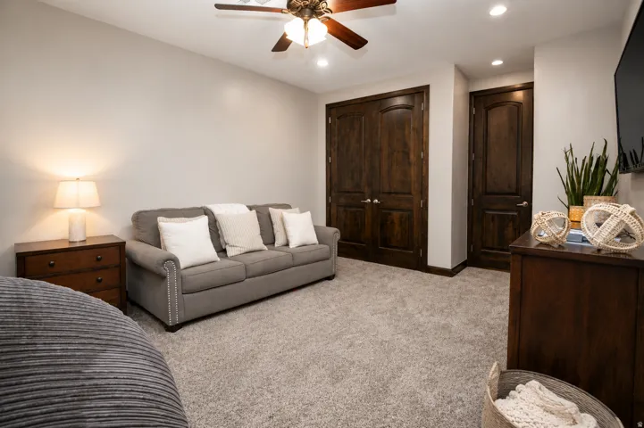 Neutral tone wall finish, wood-finish doors, recessed lighting, ceiling fan, and carpeted flooring