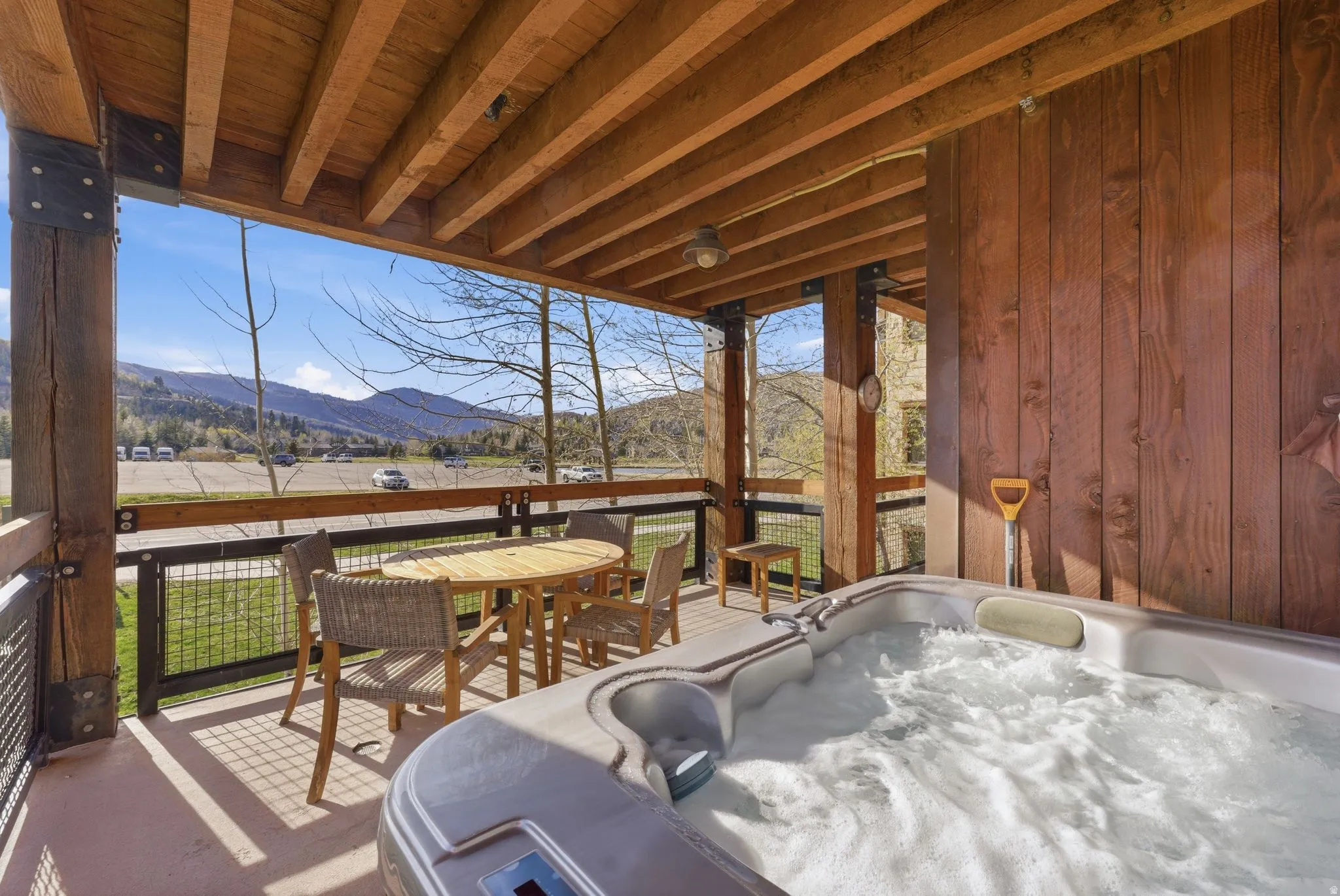Sunroom / solarium featuring a jacuzzi, outdoor dining space, and a deck with mountain view