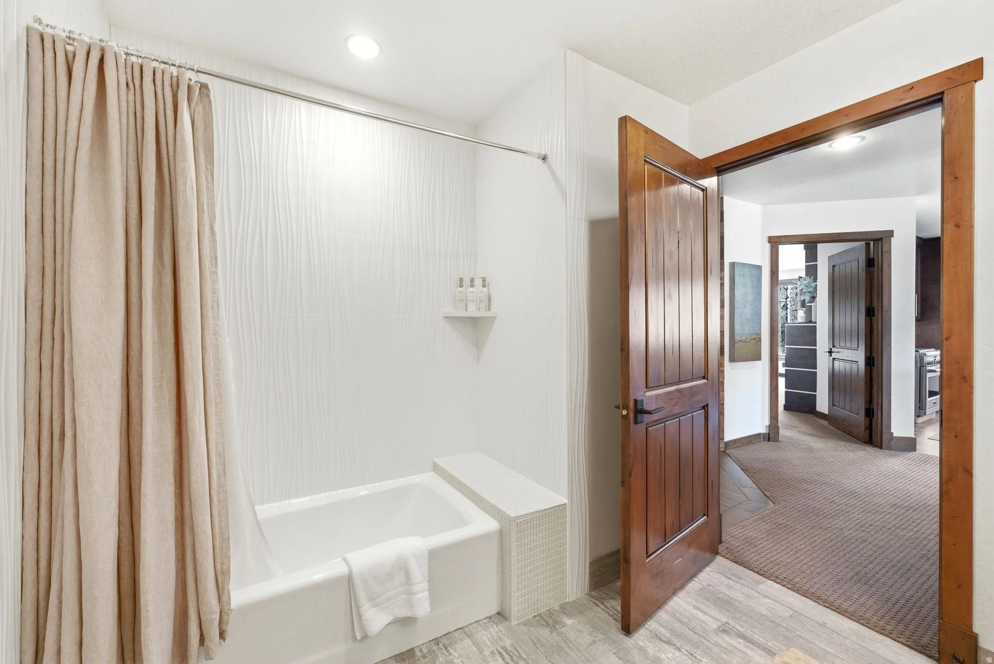 Full bath featuring shower / bath combination with curtain and light wood-style flooring