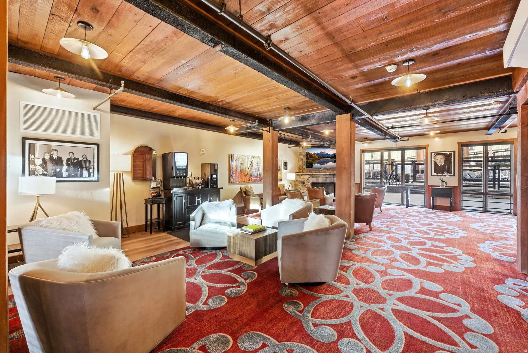 Living area featuring a wood ceiling with exposed beams, a fireplace, and wood finished floors