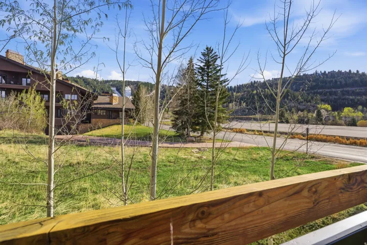 View of green lawn featuring a balcony