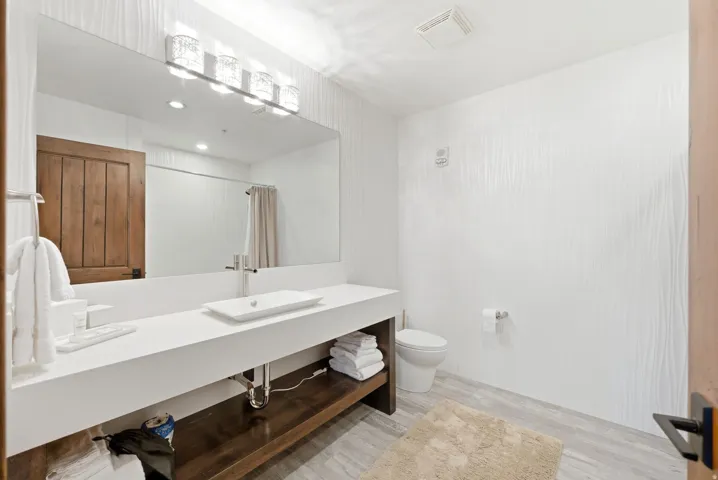 Full bathroom featuring vanity, a shower with shower curtain, and light wood-style floors