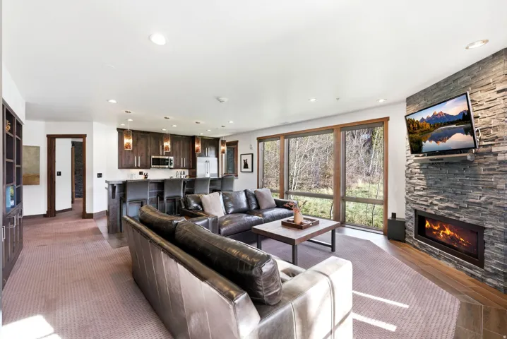 Living room with a stone fireplace and recessed lighting
