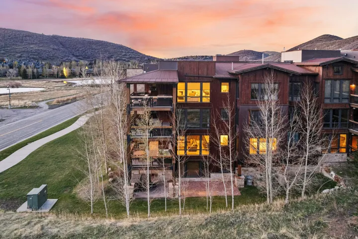 Back of property featuring a mountain view, a balcony, and a standing seam roof