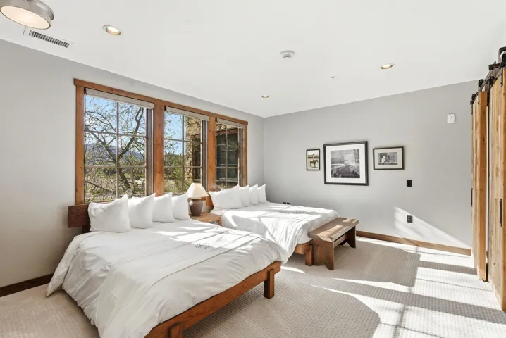 Carpeted bedroom with a barn door and recessed lighting