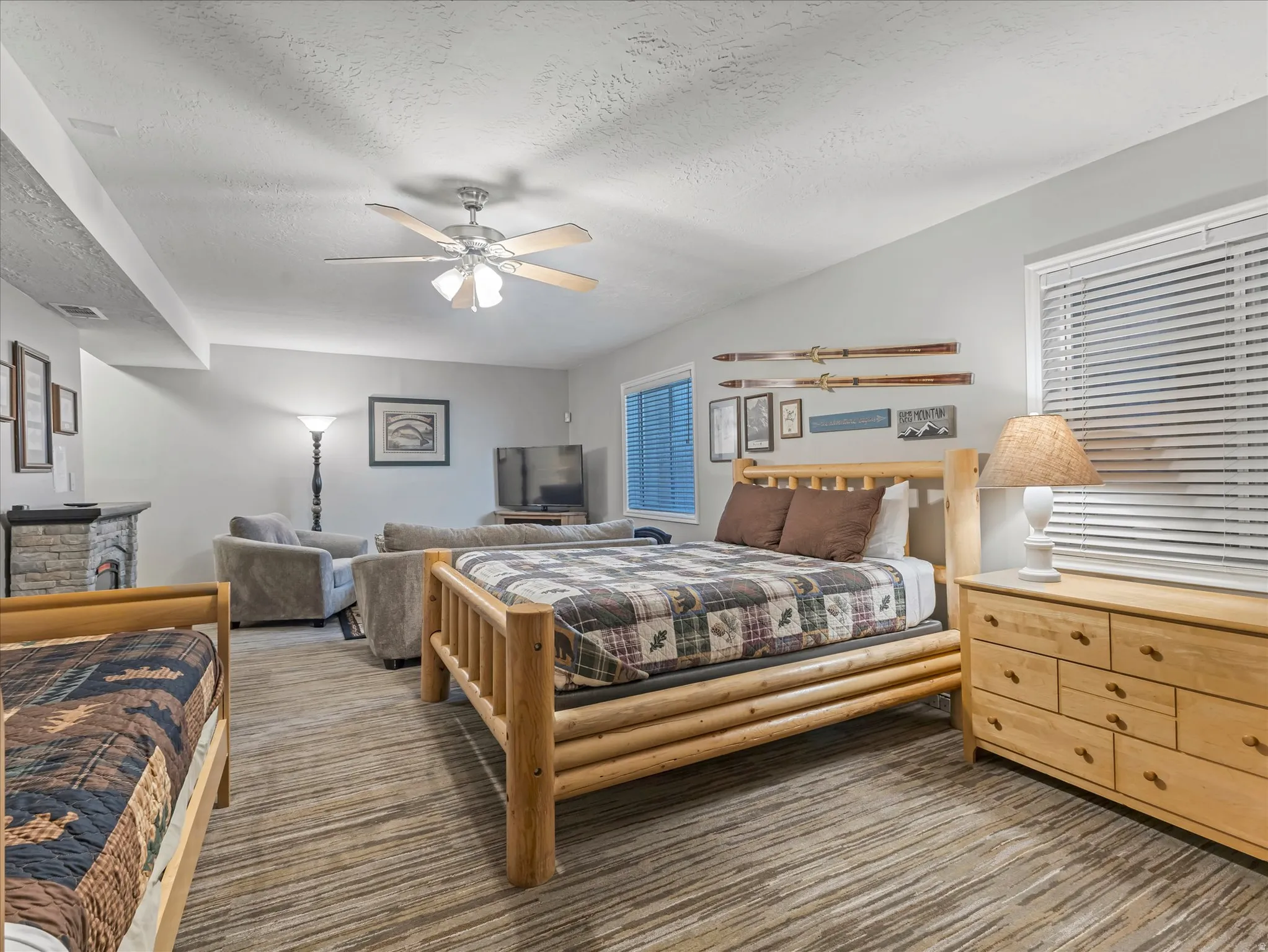 Carpeted bedroom with a textured ceiling and ceiling fan