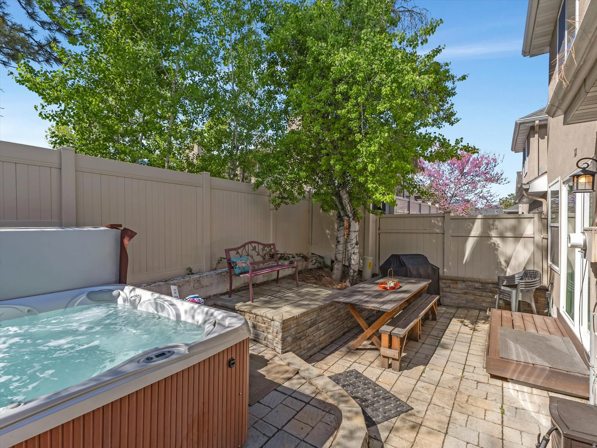 Fenced backyard with a patio area and a hot tubMa