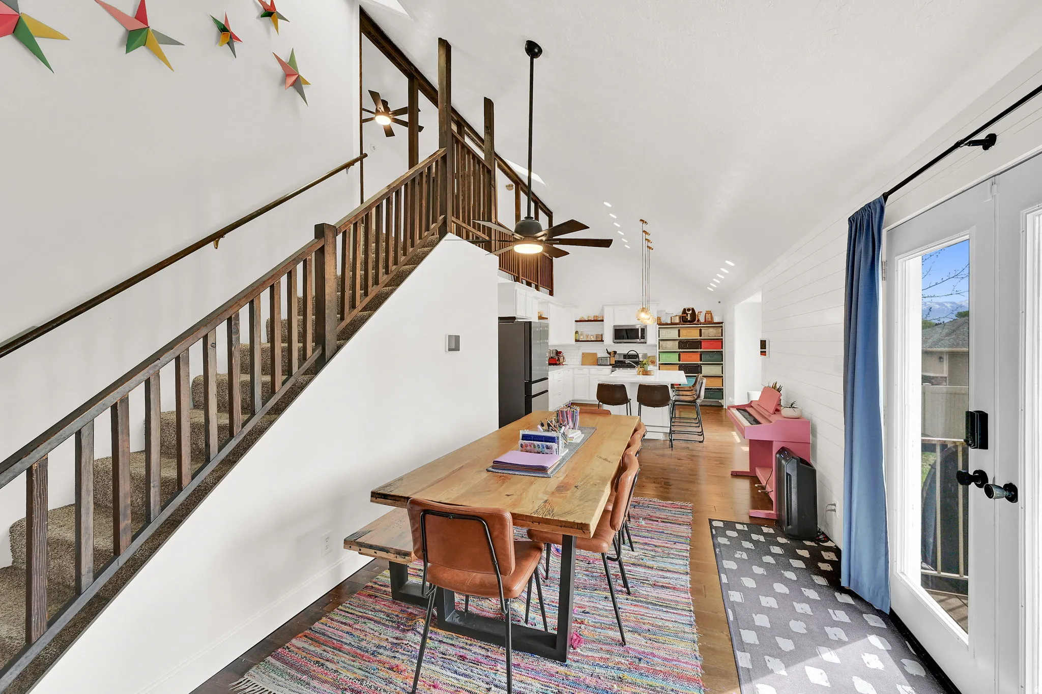 Dining area with light wood-type flooring, ceiling fan, and vaulted ceiling