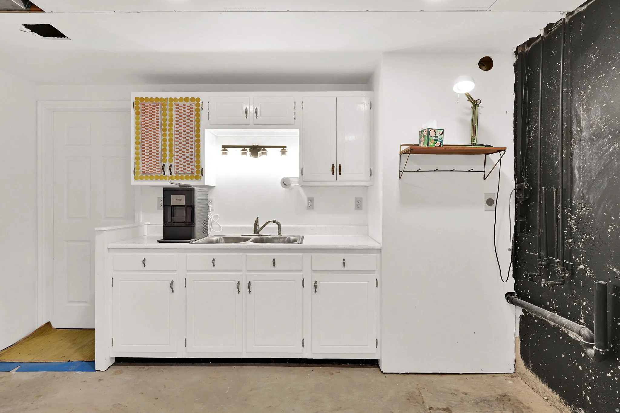 Kitchen featuring light countertops, white cabinets, and concrete floors