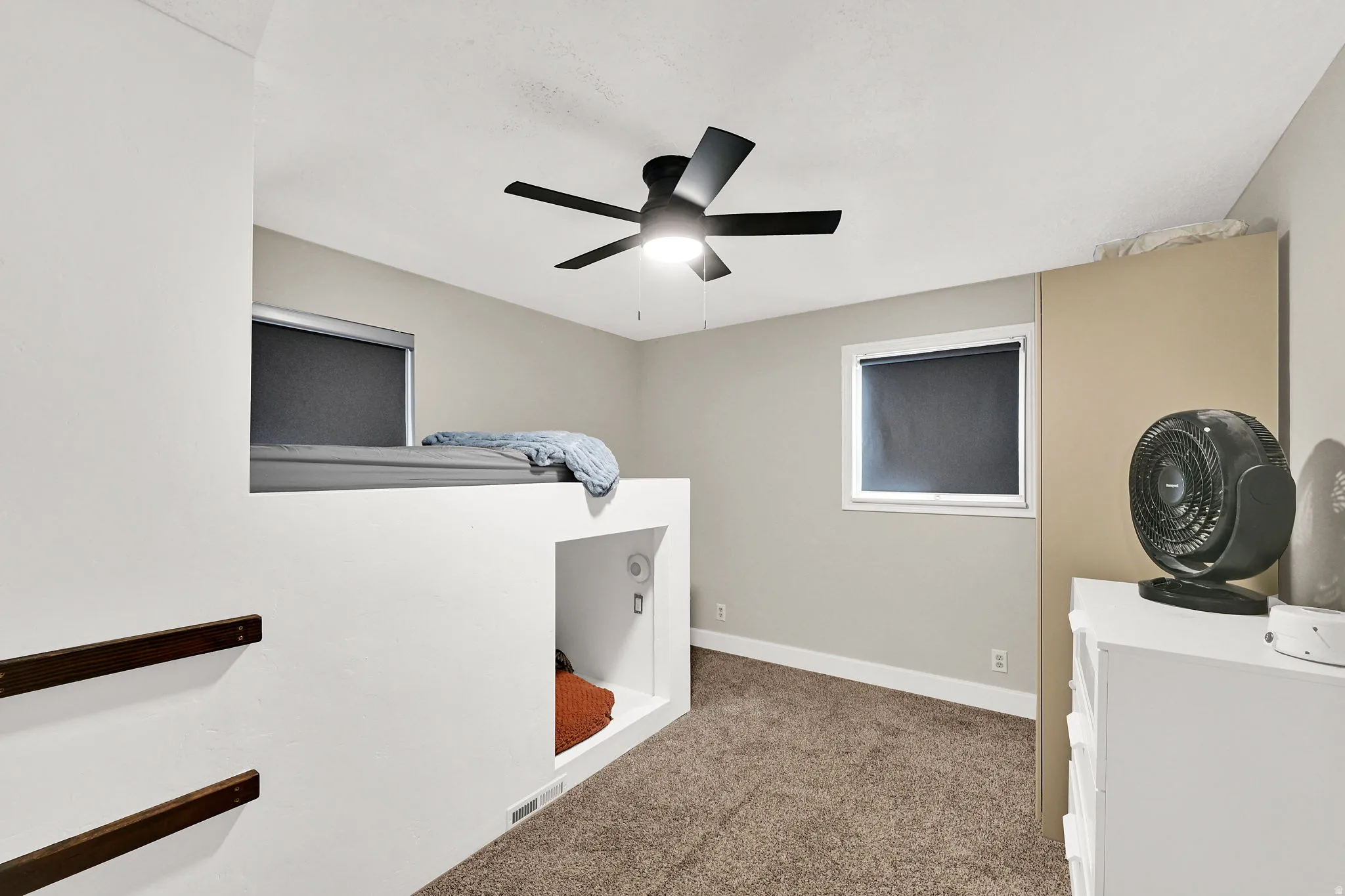 Bedroom with a ceiling fan and light colored carpet