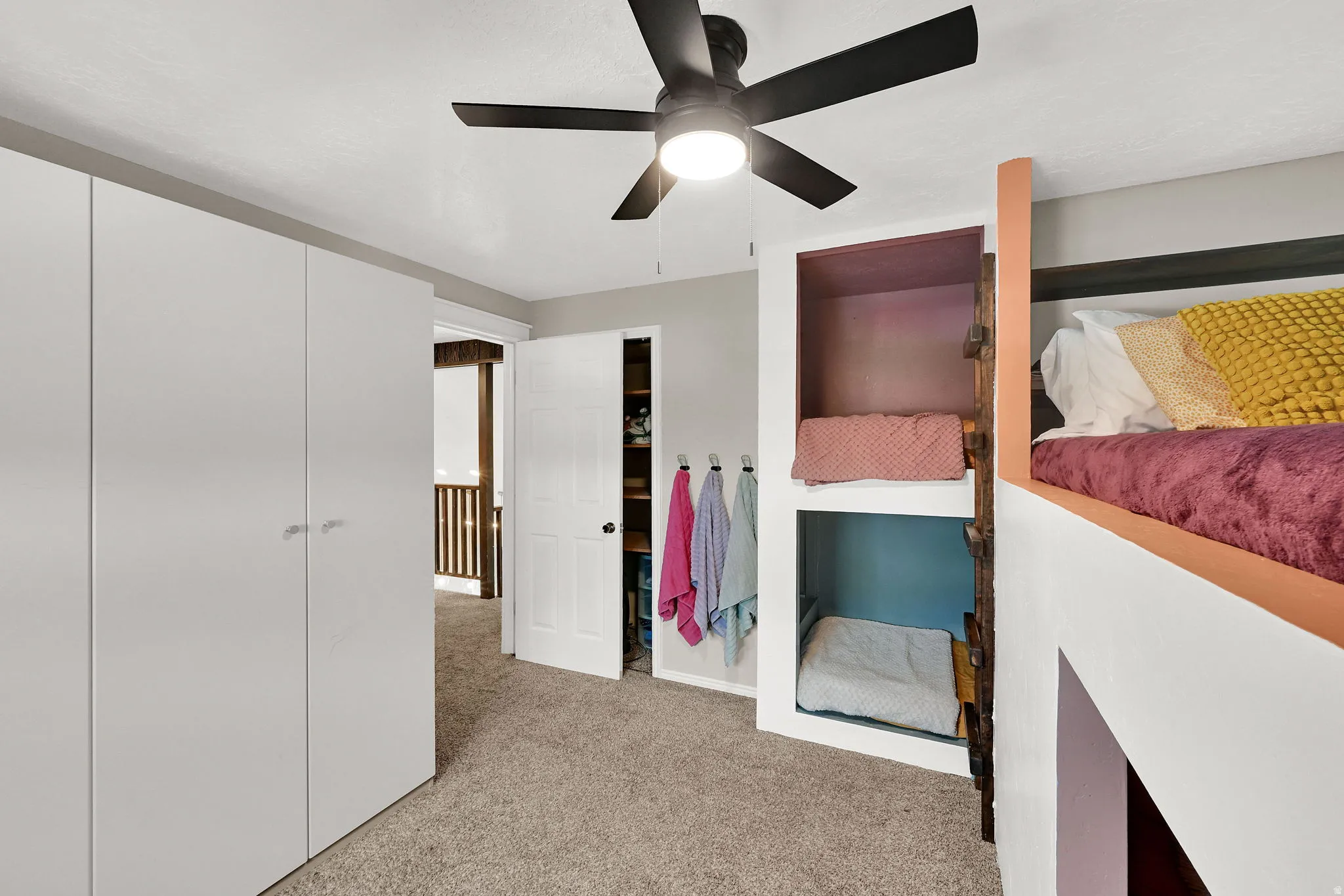 Bedroom with light colored carpet and ceiling fan