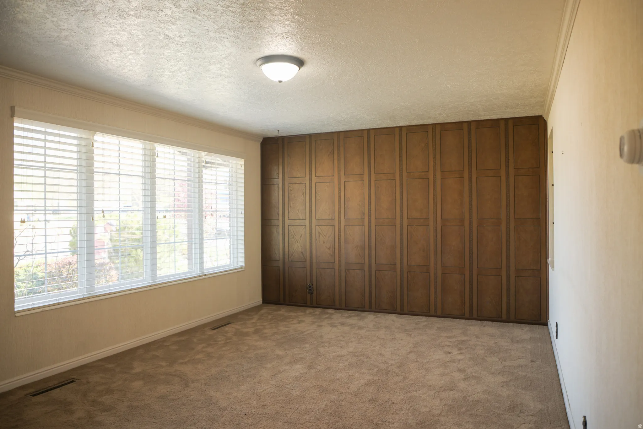 Front room with a textured ceiling and dark colored carpet