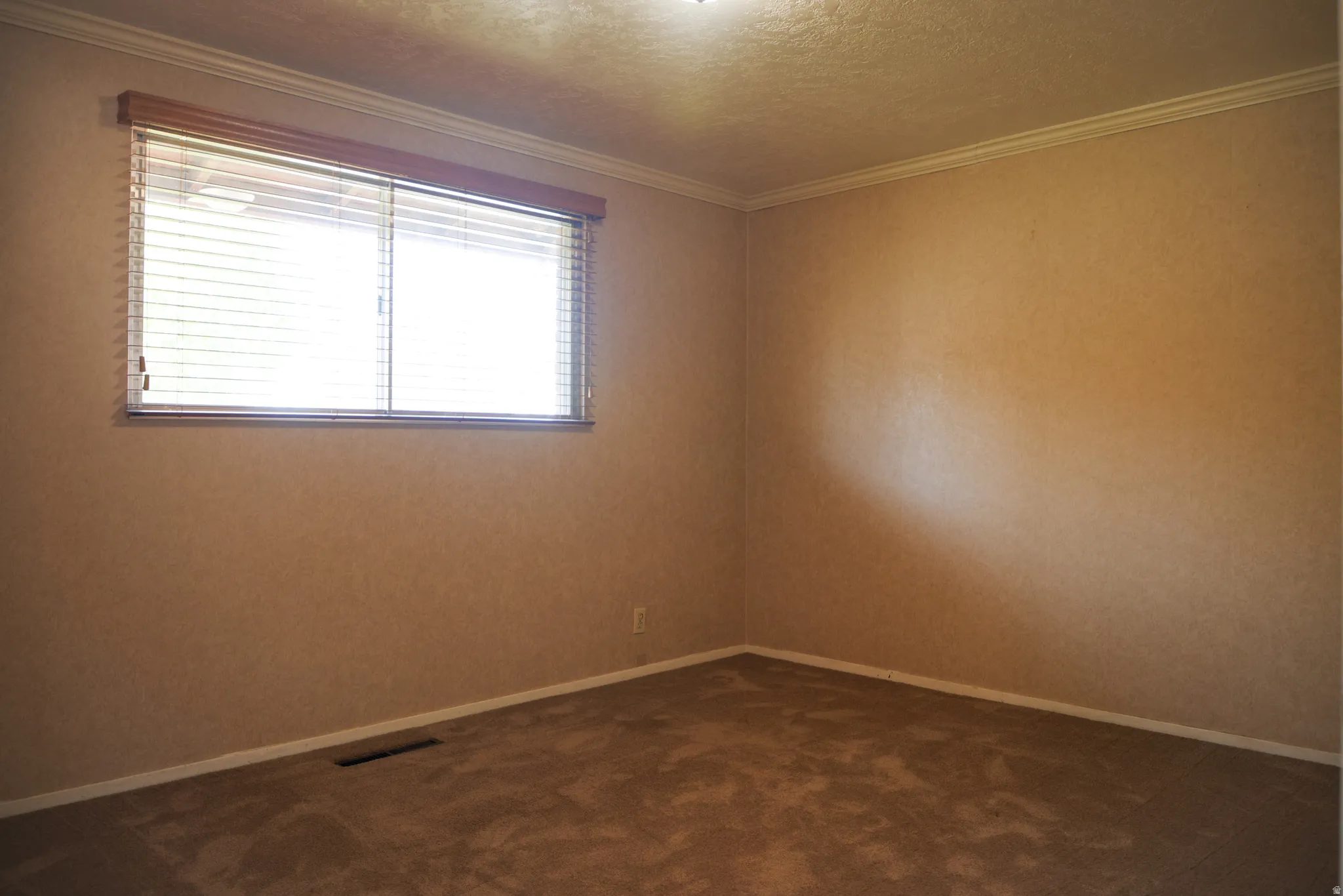Bedroom two featuring dark carpet, crown molding, and a textured ceiling