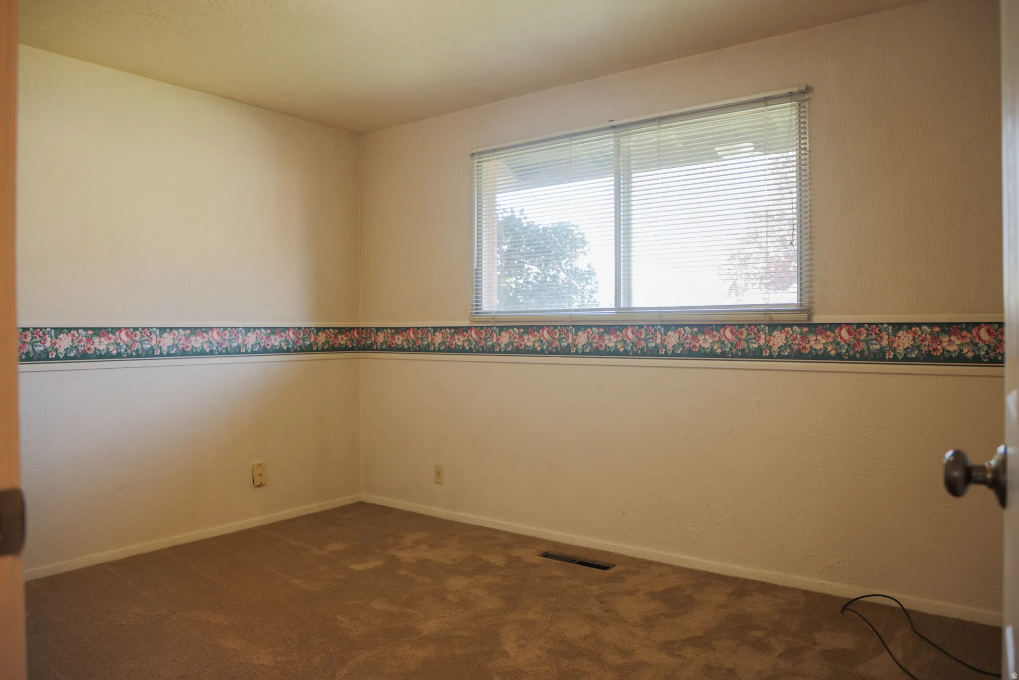 Bedroom one with dark carpet and baseboards