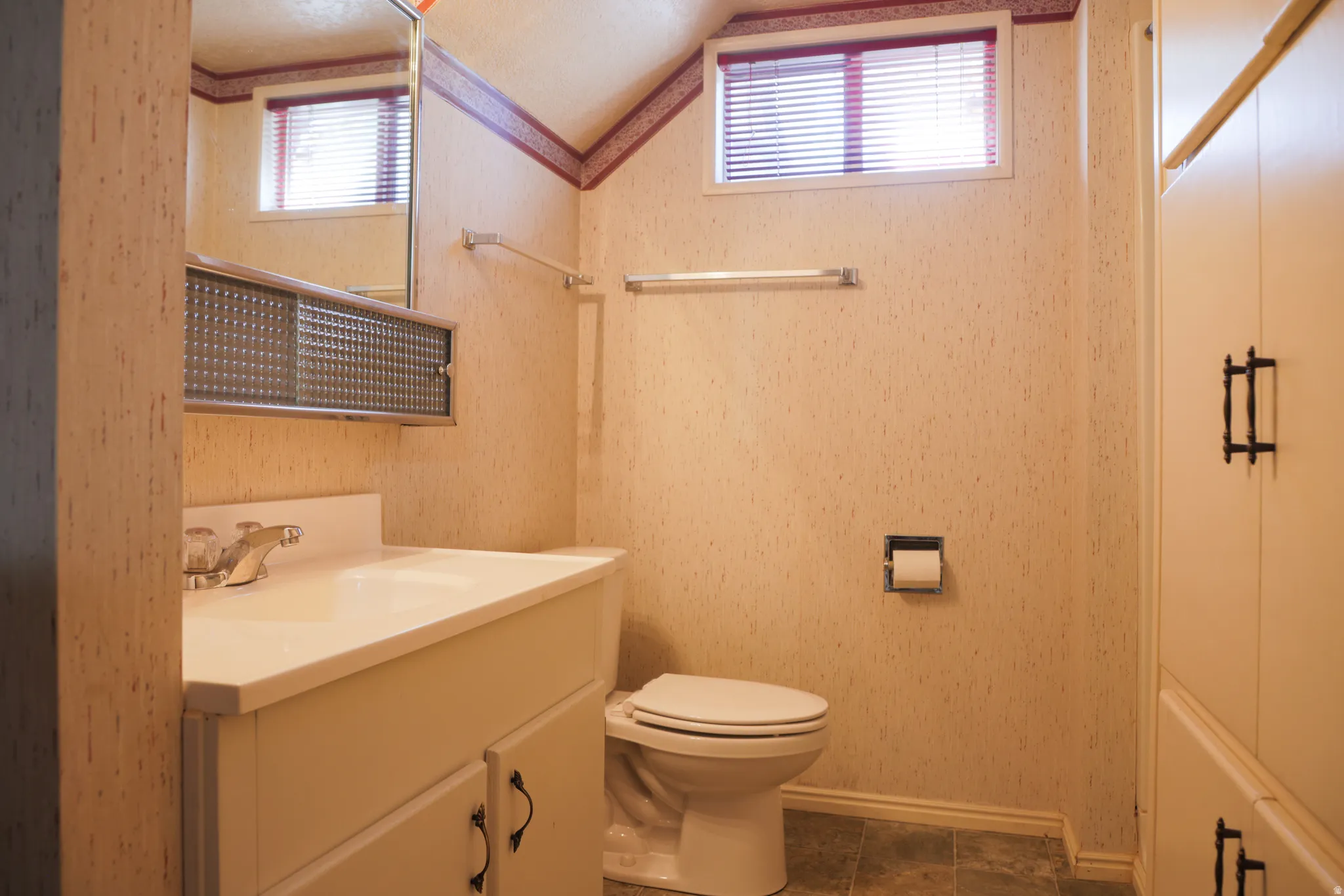 Bathroom with vanity and wallpapered walls