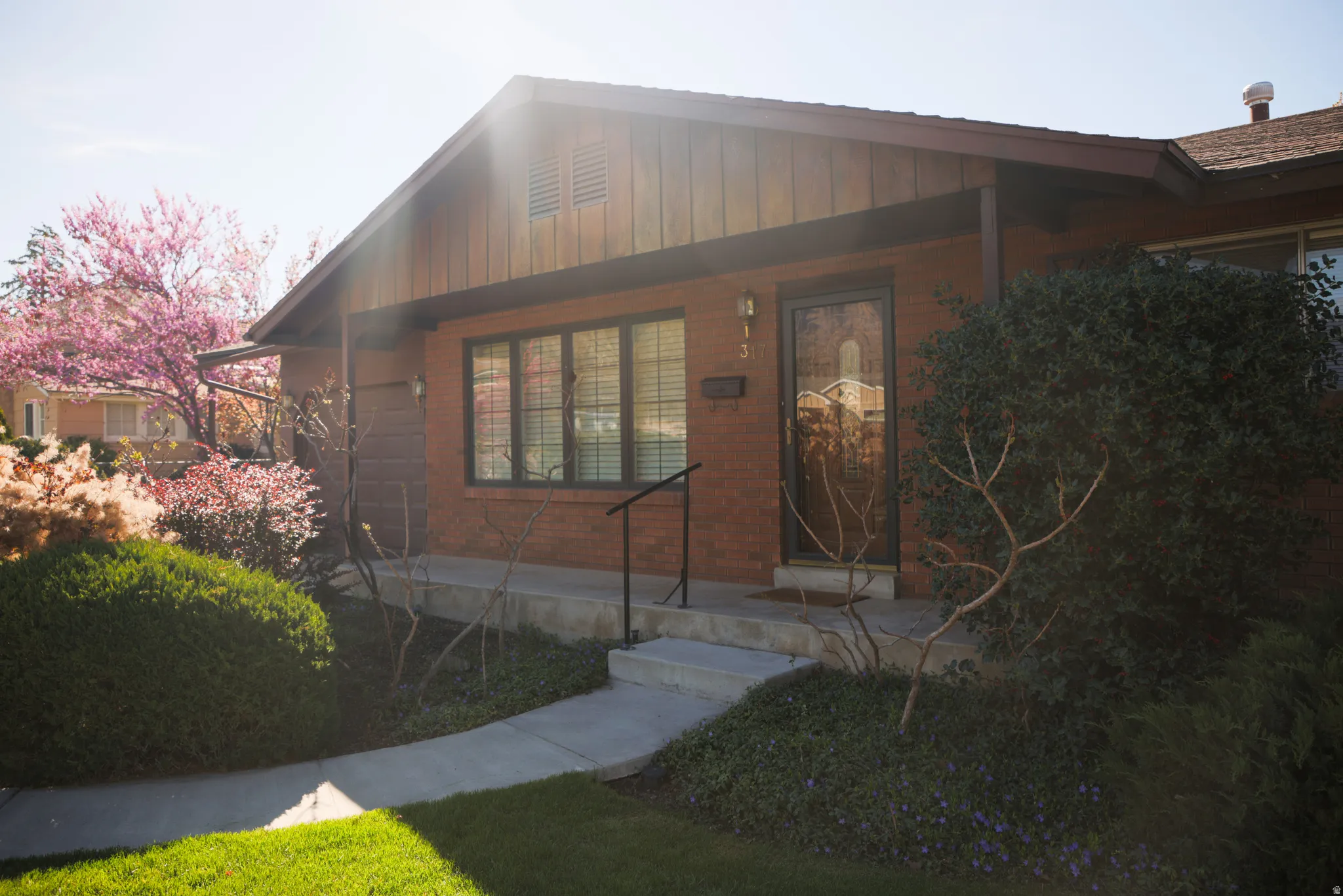 Doorway to property with board and batten siding and brick siding