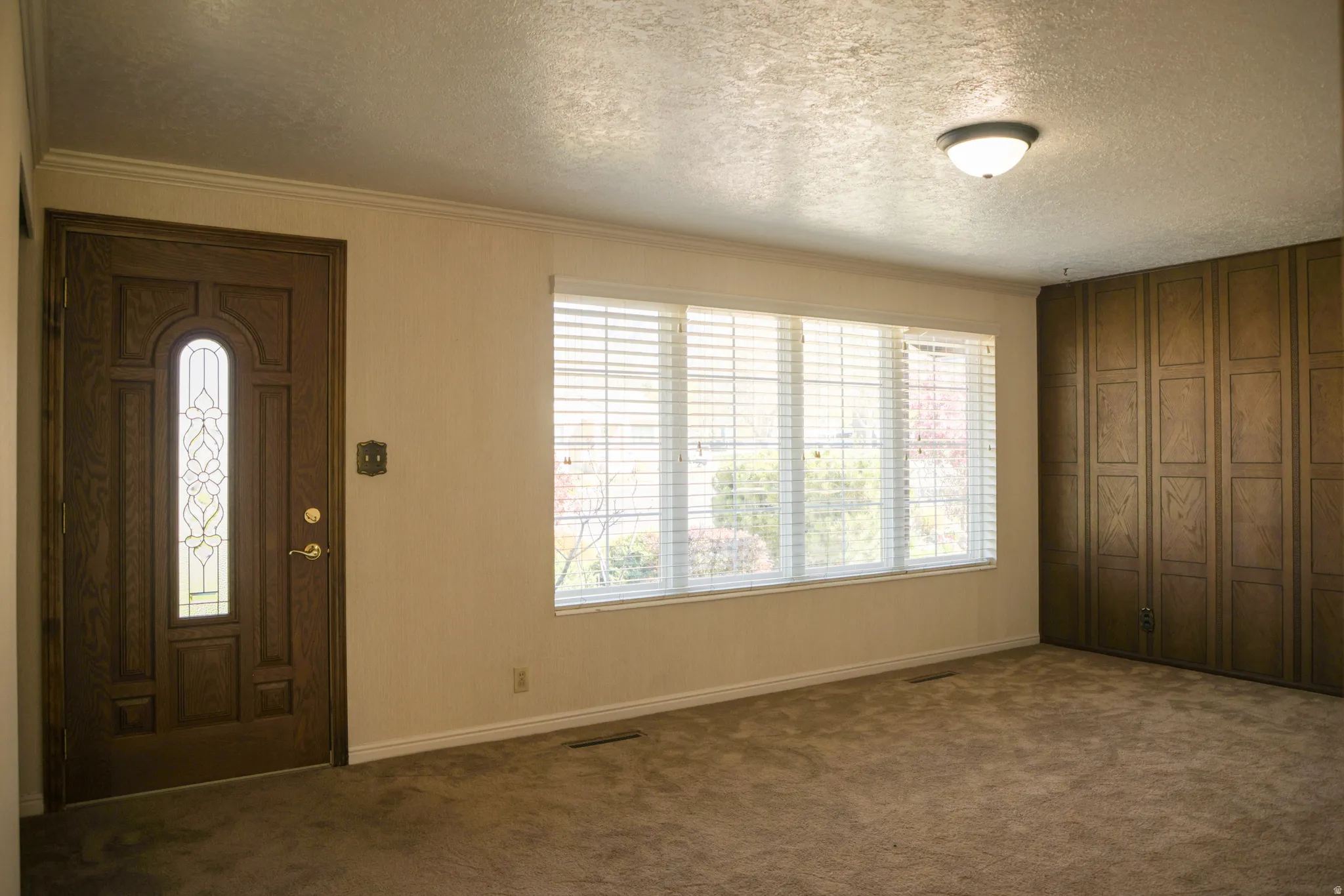 Front Room with a textured ceiling and dark colored carpet
